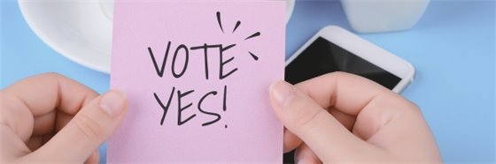 someone holding a purple sticky note that says "vote yes"