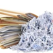 files of paper next to shredded paper