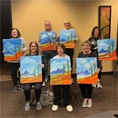 group of residents holding paintings