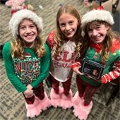 three girls with matching slippers and Christmas PJs