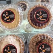 four mini pies in plastic containers with a momma toledos sticker
