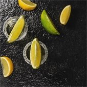 black background with lemons and limes on glasses