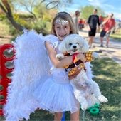 girl in an angel costume with her dog