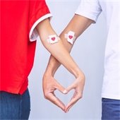 two people with locked arms forming a heart with their hands