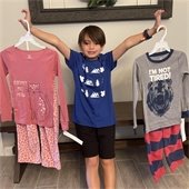 Boy holding two pairs of pajamas
