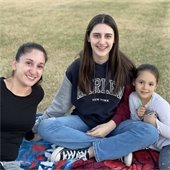 mom and two daughters at movie in the park event